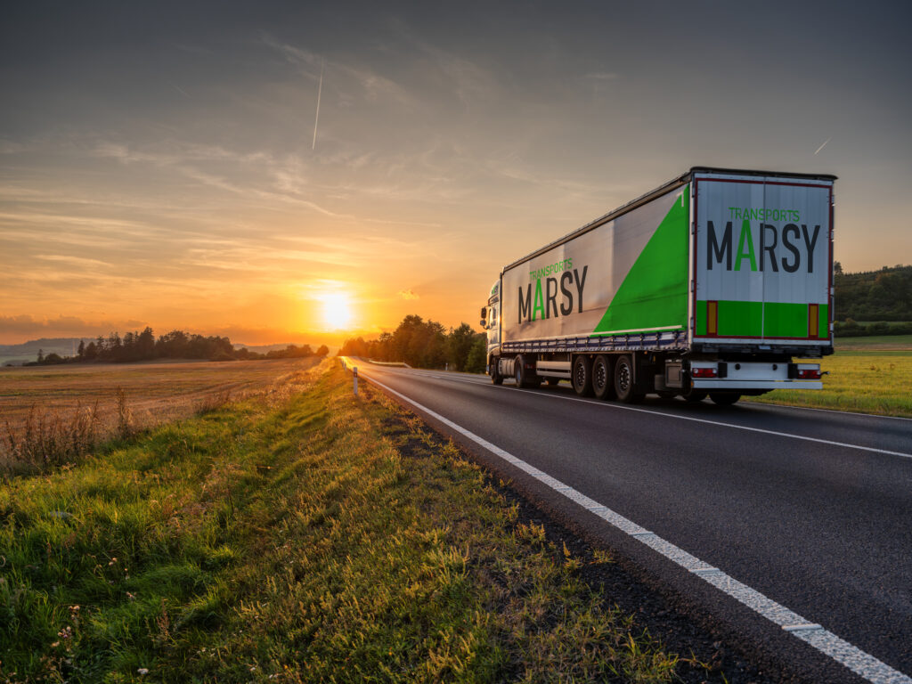 Photo d'un camions Marsy Transport sur la route faisant face au couché du soleil